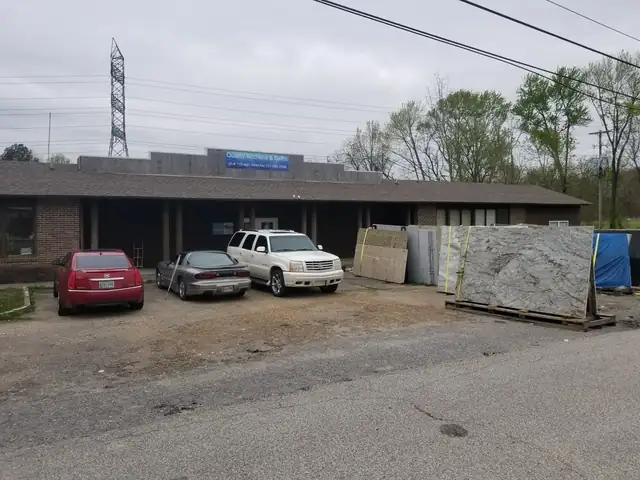 Granite slabs in white, grey and tan standing on racks beside the shop